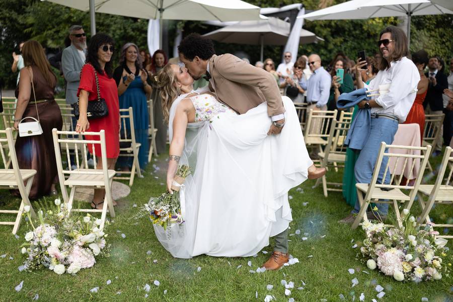 Groom carries the bride down the aisle after the ceremony — wedding in Azeitão