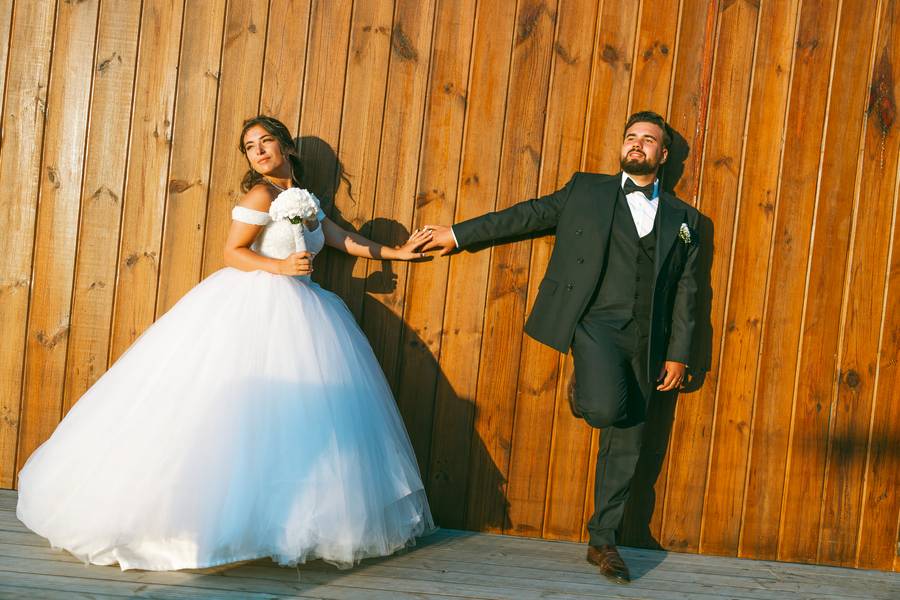 Couple laughing against a wooden wall — wedding in Setúbal
