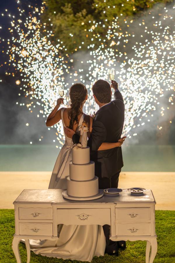 Couple cutting the cake under sparklers — wedding in Azeitão