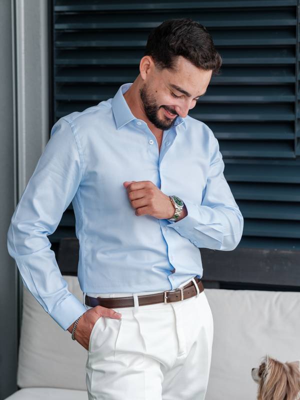 Groom smiling as he gets dressed — wedding in Comporta