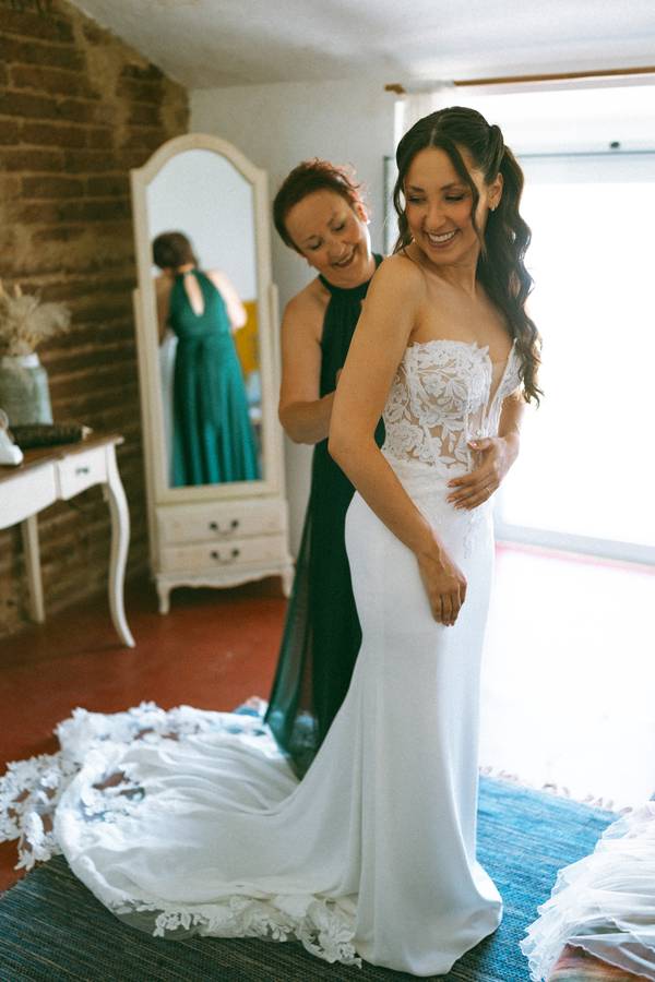 Maid of honour helping the bride with her dress — wedding in Évora