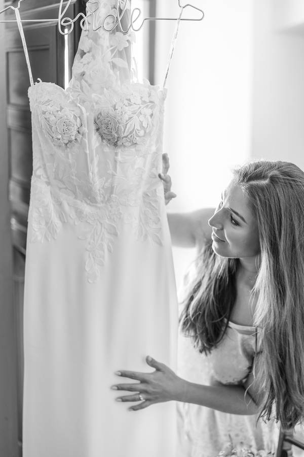 Bride looking at her hanging dress — wedding in Óbidos