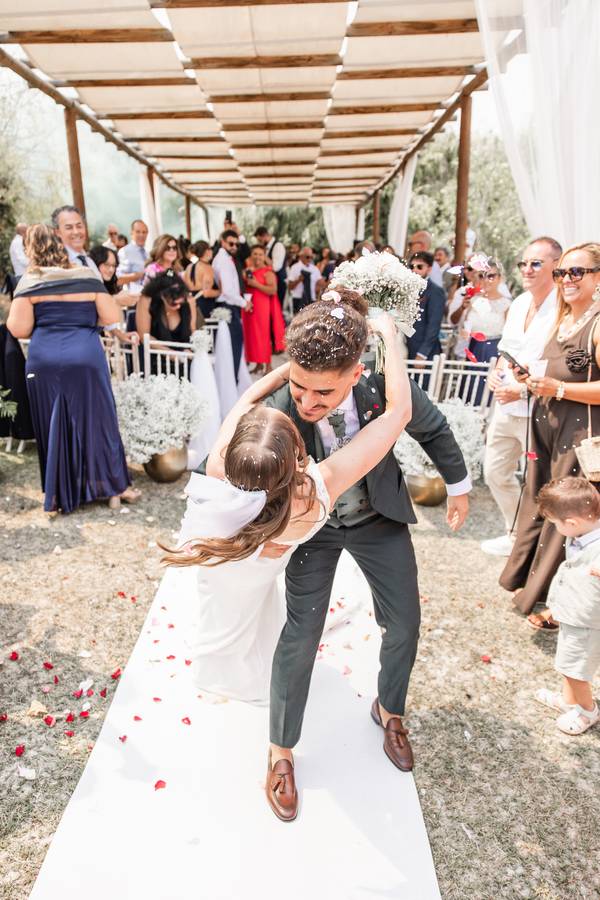Groom lifting the bride on the ceremony aisle — wedding in Setúbal