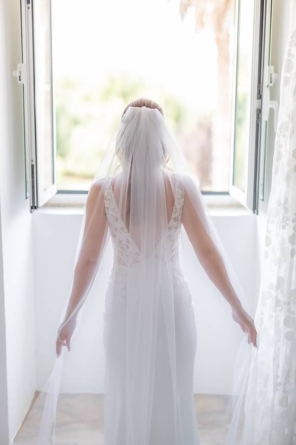 Bride from behind opening the window — wedding in Setúbal