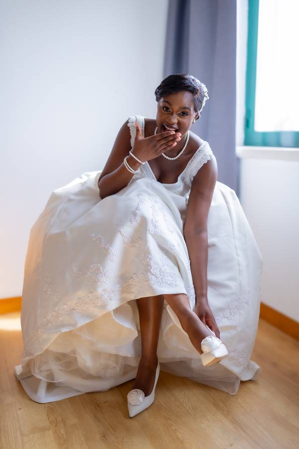 Bride laughing as she puts on her shoes — wedding in Lisbon